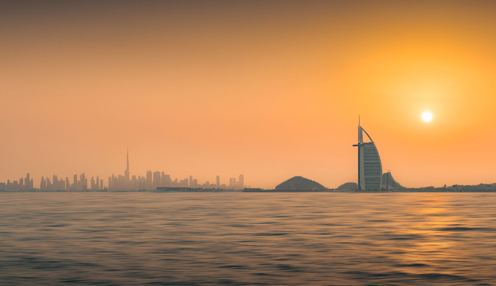 The Dubai skyline seen across the water at sunset